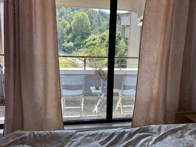 a bedroom with a view of a balcony with a table and chairs at Nikol5 Deluxe in Velingrad