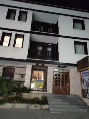 a white building with windows and doors and stairs at Топ локация! in Bansko