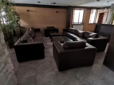 a living room with black leather couches at Топ локация! in Bansko