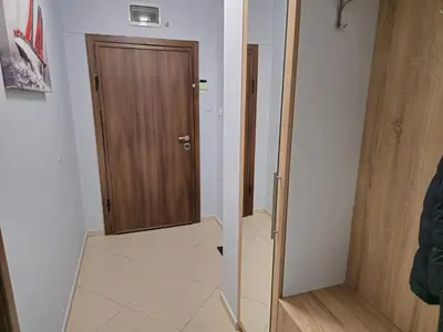 a hallway with a wooden door and a tile floor at Къща за гости Спирката 2 in Hotovo