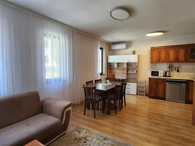 a living room and kitchen with a couch and a table at Trinity Apartment & Pool with Spa Near Center in Bansko