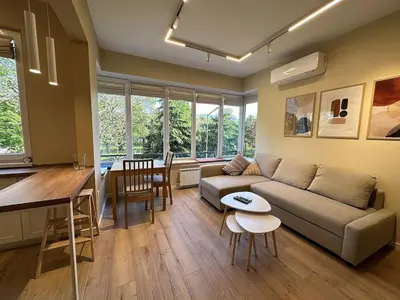 a living room and kitchen with a couch and a table at Park Apartment in Sofia