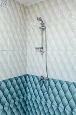 a shower in a bathroom with blue and white tiles at Hrisi&Kris in Sapareva Banya