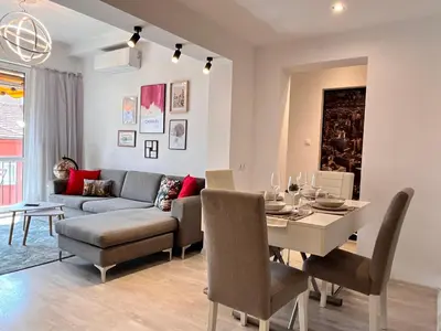 a living room and dining room with a table and a couch at Central 53 Vitosha View 2BD Apartment in Sofia