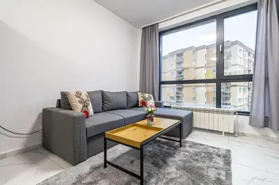 a living room with a couch and a table at Vitosha view Mladost apartment in Sofia