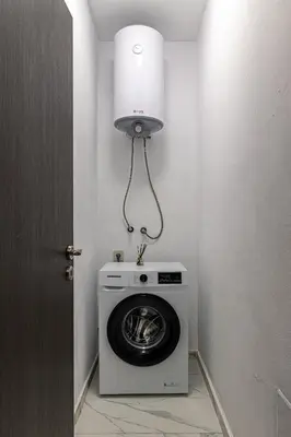 a laundry room with a washing machine and a light at Vitosha view Mladost apartment in Sofia