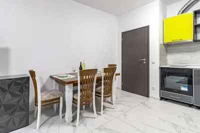 a dining room with a table and chairs in a kitchen at Vitosha view Mladost apartment in Sofia