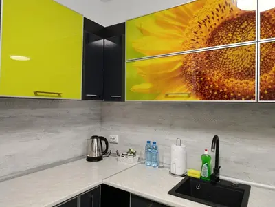 a kitchen counter with a sunflower painting on the wall at Vitosha view Mladost apartment in Sofia