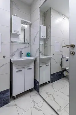 a white bathroom with two sinks and a mirror at Vitosha view Mladost apartment in Sofia