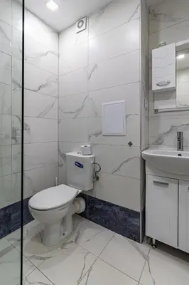 a white bathroom with a toilet and a sink at Vitosha view Mladost apartment in Sofia