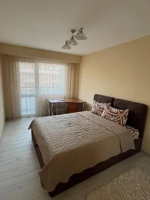 a bedroom with a bed and a table and a window at Contemporary Comfort in Lozenets in Sofia
