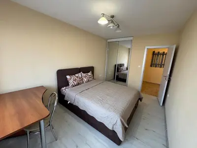 a bedroom with a bed and a table in it at Contemporary Comfort in Lozenets in Sofia