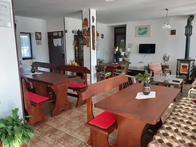 a living room with wooden tables and chairs at Стаи за гости ЖиВел in Oreshak