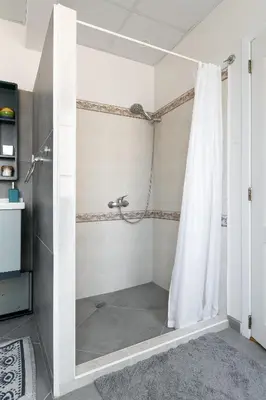 a shower with a shower curtain in a bathroom at MOD - Opera Plovdiv in Plovdiv