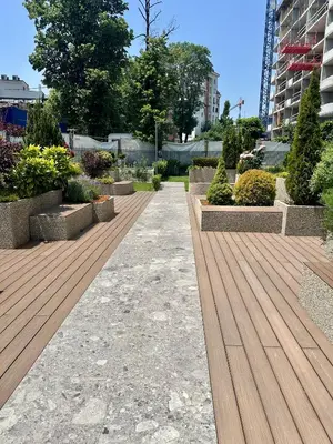 a walkway in a park with plants and a building at The Skyline Residence Sofia in Sofia