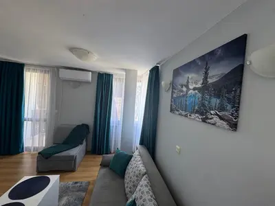 a living room with a couch and blue curtains at Apartment 2-6 Royal Park in Bansko