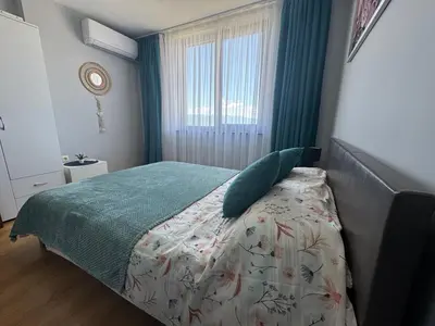 a bedroom with a bed with a green comforter and a window at Apartment 2-6 Royal Park in Bansko