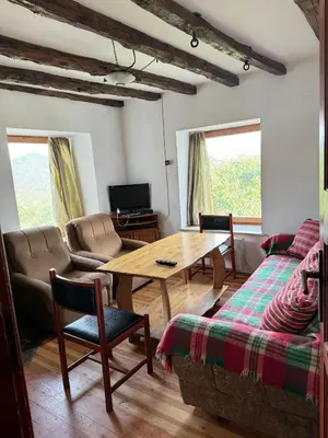 a living room with a table and a couch at Guest House in Rhodope Mountains in Rudozem