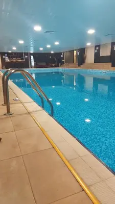 a large swimming pool with blue water in a building at Aпартамент за гости SKI DREAM Grand Monastery-Пампорово in Pamporovo