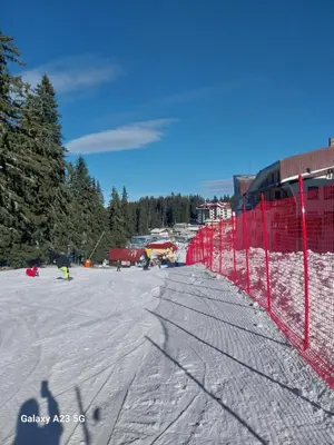 a ski slope with a red fence in the snow at Aпартамент за гости SKI DREAM Grand Monastery-Пампорово in Pamporovo