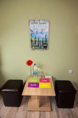 a table with two stools and a sign on the wall at SimplyComfy in Plovdiv