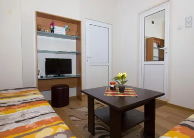 a living room with a table and a tv at SimplyComfy in Plovdiv