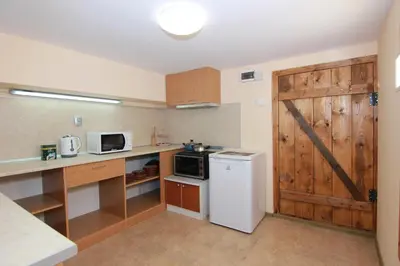 a kitchen with a white refrigerator and a wooden door at SimplyComfy in Plovdiv
