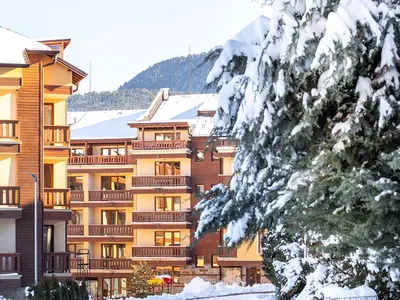 a large apartment building with snow on the ground at Cozy 1BD Flat in Pirin Sense by Flat Manager in Bansko