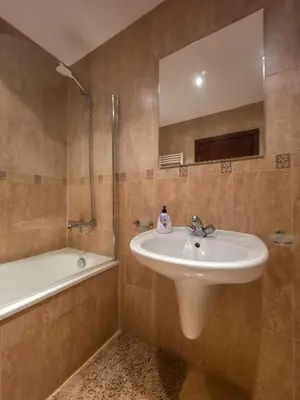 a bathroom with a sink and a mirror and a tub at Charming 1BD Flat at Edelweiss Inn, Bansko by Flat Mаnager in Bansko