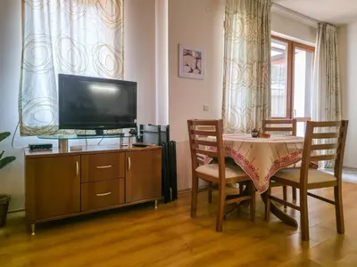 a living room with a table and a flat screen tv at Charming 1BD Flat at Edelweiss Inn, Bansko by Flat Mаnager in Bansko