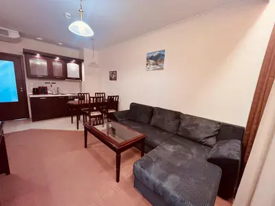 a living room with a black couch and a table at Gondola luxury apartment 1 in Bansko