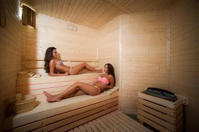 two women are sitting in a sauna at Mantar Spa Hotel in Marikostinovo