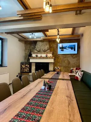 a large wooden table in a room with a fireplace at Villa Veranda in Smolyan