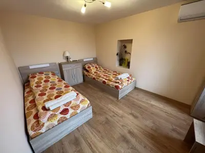 two beds in a small room with wooden floors at Villa Geshevi in Hisarya