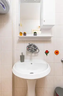 a bathroom with a white sink and a mirror at Spacious 2BR Apt Kremena 10 minutes walk to Center in Plovdiv