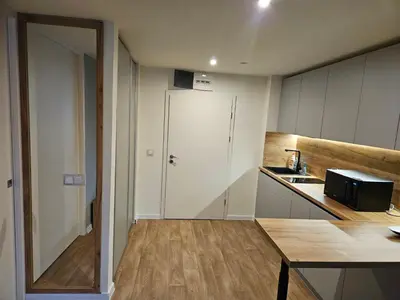 a small kitchen with a white door and a table at Приказна гледка B5 2 in Borovets