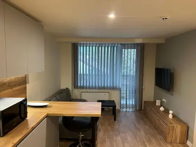 a kitchen and living room with a table and a microwave at Приказна гледка B5 2 in Borovets
