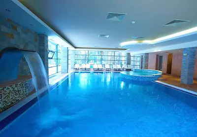 a large swimming pool with a water feature in a building at Приказна гледка B5 2 in Borovets