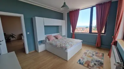 a bedroom with a bed and a large window at Boho Style in Samokov