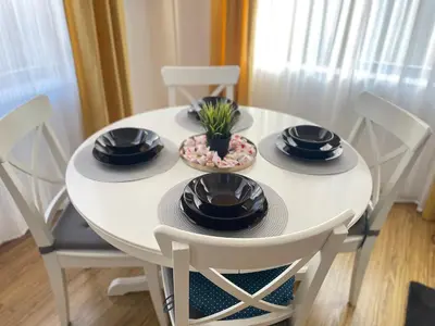 a white dining room table with black dishes on it at Hrebet House in Borovets