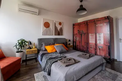 a bedroom with a bed and a red wooden door at Mall of Sofia - UrbanLux Ampla 2BDR FREE Parking in Sofia