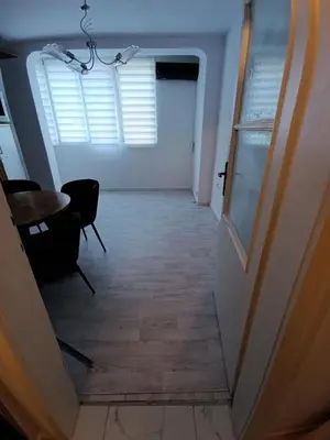 a hallway with a door and a table and chairs at АПАРТАМЕНТ ДВЕ СТАИ ДО МЕТРОСТАНЦИЯ ВАРДАР Apartment In West Park near Subway in Sofia
