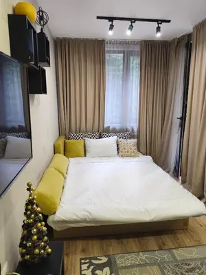 a bedroom with a large bed with a christmas tree at Borovets Gardens Forest STUDIO A3 - FREE PARKING,Free baby cot in Borovets