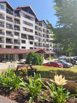 a large apartment building with cars parked in a parking lot at Borovets Gardens Forest STUDIO A3 - FREE PARKING,Free baby cot in Borovets