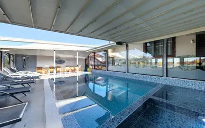 an indoor swimming pool with chairs and a house at Complex Koko Hills in Sapareva Banya