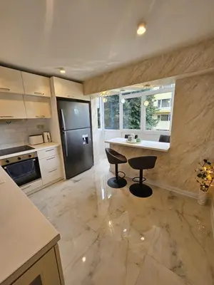 a kitchen with a table and a black refrigerator at Apartment Home in Troyan