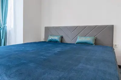 a bedroom with a large blue bed with two pillows at Sofia Downtown Apartment in Sofia