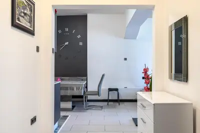 a room with a clock on the wall and a desk at Sofia Downtown Apartment in Sofia