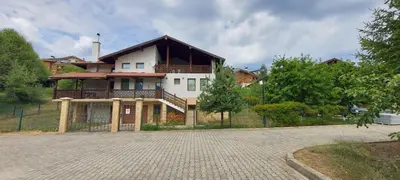 a large house with a balcony on a driveway at 19 Rose in Bansko