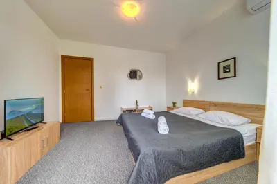 a bedroom with a bed and a flat screen tv at Villa Kometa - 1BD Apt with Balcony & Forest View by Flat Manager in Pamporovo